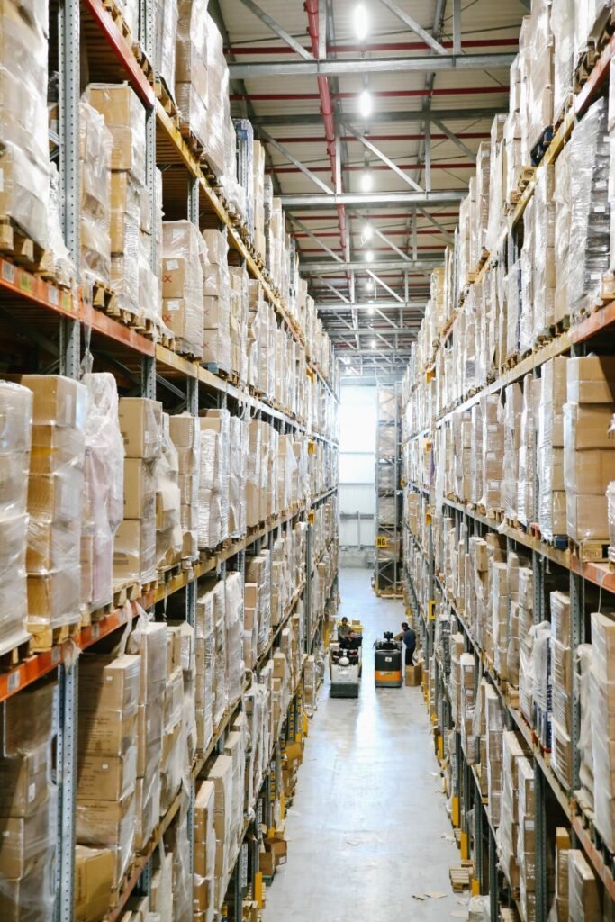 Warehouse shelving with cartons stored in organized aisles.